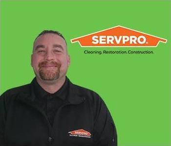 A man in front of SERVPRO logo on a green screen