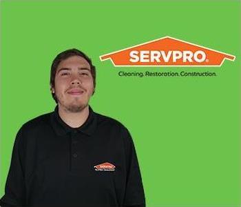 man standing in front of a SERVPRO Logo