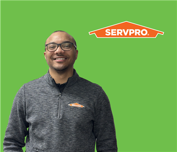 SERVPRO employee with glasses wearing a grey shirt in front of a white background
