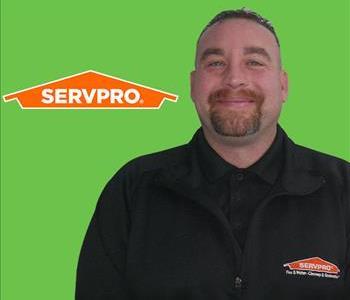 A man in front of SERVPRO logo on a green screen